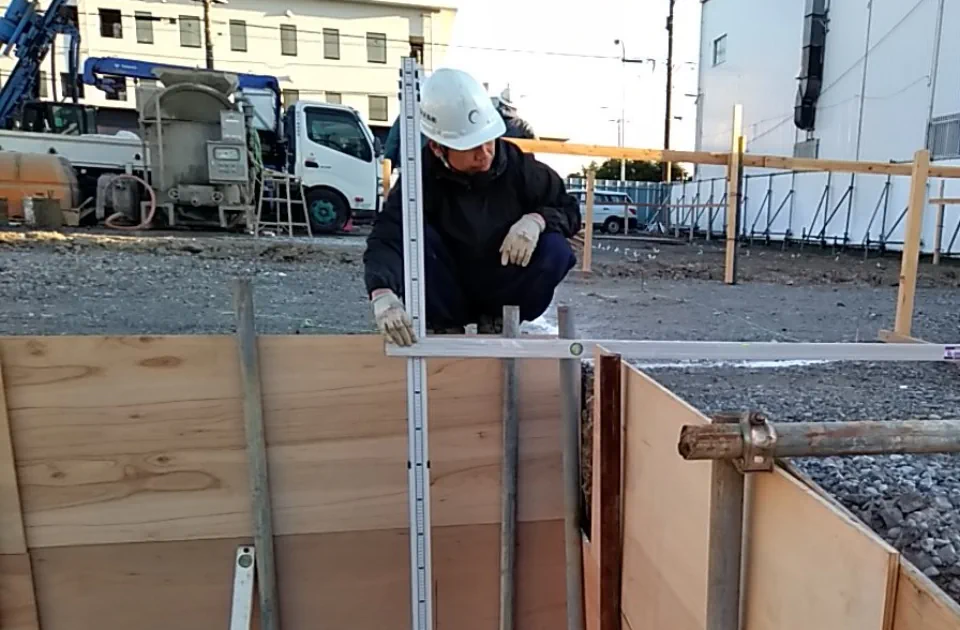 雨水貯留槽設置工事で高さを確認する作業員